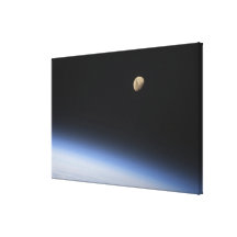 A gibbous moon visible above Earth's atmosphere Stretched Canvas Prints