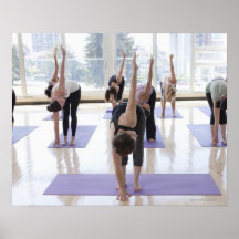 class practicing yoga with instructor in a posters