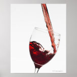 Close up of red wine being poured into glass on print