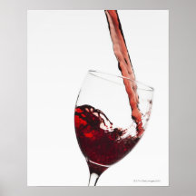 Close up of red wine being poured into glass on print