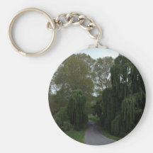 Curved road down a country lane lined green trees keychains