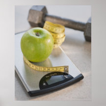 Green apple on weight scale, tape measure and posters