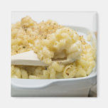 Macaroni cheese in baking dish with wooden refrigerator magnets