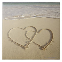 Two overlying hearts drawn on the beach with tiles