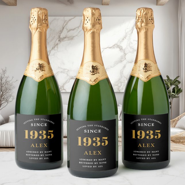 90th Birthday Name 1935 Black Gold Elegant Chic Sparkling Wine Label (Three custom 90th birthday wine labels on sparkling wine bottles in modern room.)