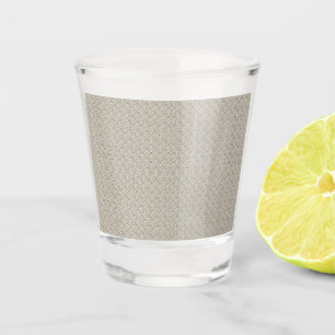 a beige background with a pattern of small squares shot glass
