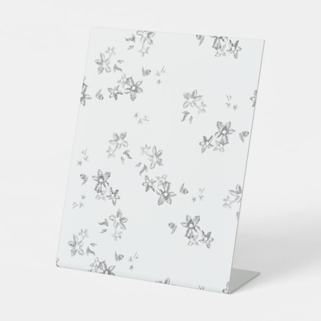 a black and white photo of snow flakes pedestal sign (Front)