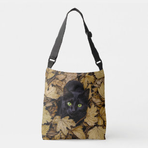 A black cat is playing in the autumn leaves crossbody bag