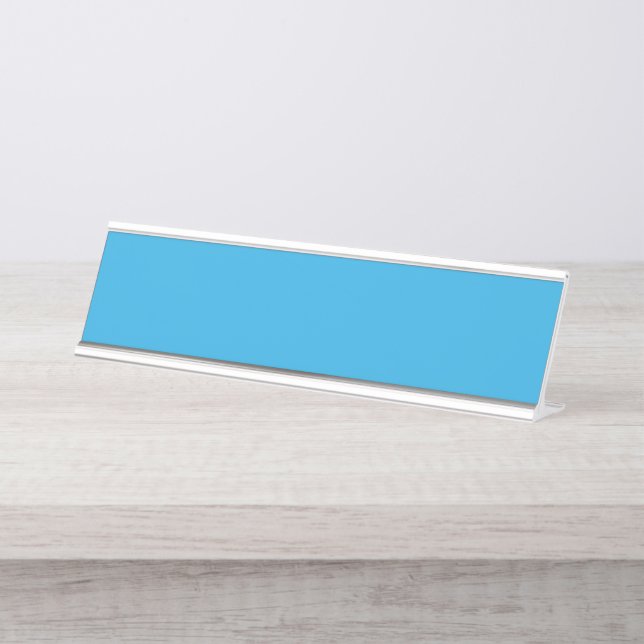 a blue background with a black and white cat on to desk name plate (Front)