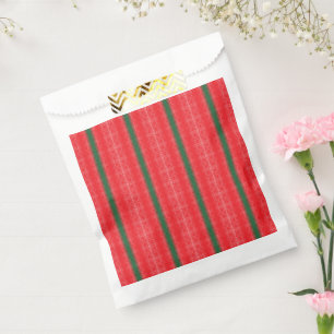 A bright red apple sits on a plain white surface. favour bags