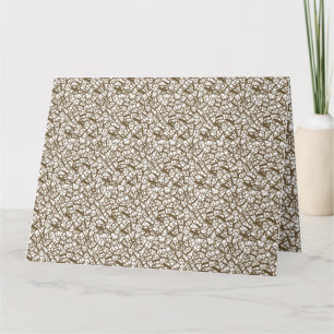 A brown rug with a geometric motif is partially co card