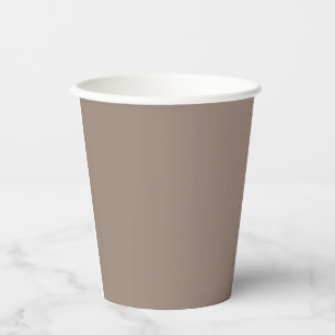 a brown wall with a clock on it paper cups