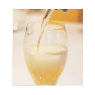 A champagne glass flute being filled with Gosset Notepad