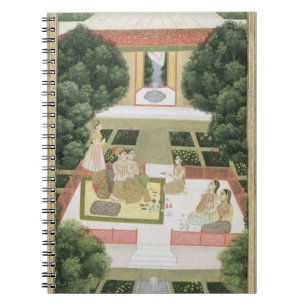 A couple in a garden listening to music with femal spiral notebook