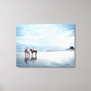 A couple riding horses on Parkiri beach in New Canvas Print