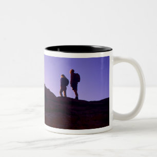 A couple watches sunrise from atop Mesa Arch in Two-Tone Coffee Mug