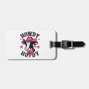 A cow wearing a vibrant pink cowboy luggage tag