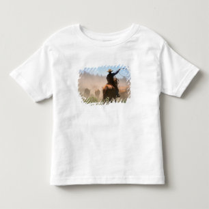 A cowboy out working the herd on a cattle toddler T-Shirt
