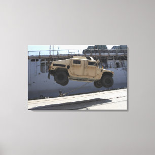 A crane lifts an M998 Humvee Canvas Print