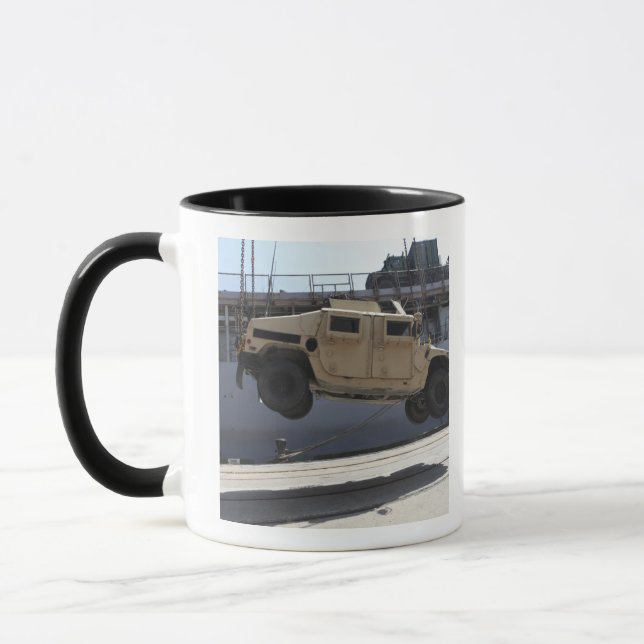 A crane lifts an M998 Humvee Mug (Left)