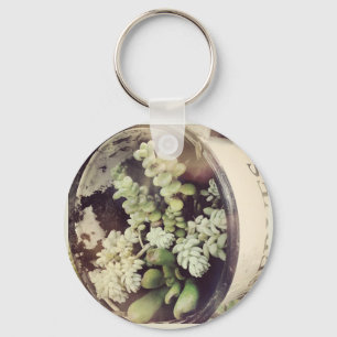 A cup full of succulent plants key ring