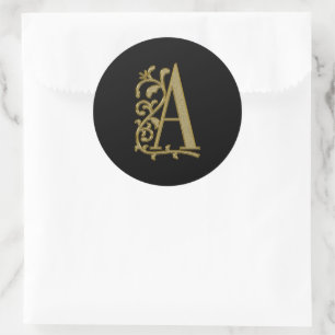 A curly monogram on black classic round sticker