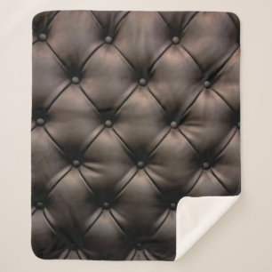 A dark leather cushion background, from a car seat sherpa blanket