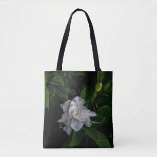 A delicate white flower blooms  tote bag
