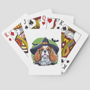 A dog wearing a witches hat with bats playing cards