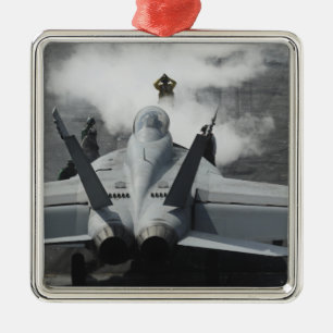 A flight deck director signals an F/A-18F Metal Tree Decoration