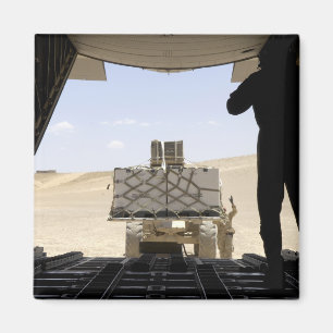 A forklift loads cargo onto a C-130 Hercules Magnet