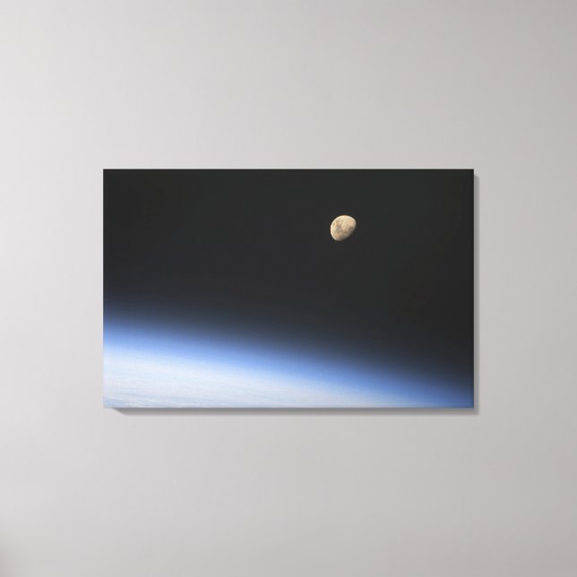A gibbous moon visible above Earth's atmosphere Canvas Print (Front)
