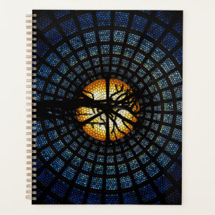 A glass plant with a tree in the middle planner