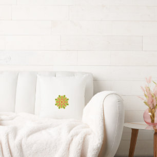 a green and red flower with black dots cushion