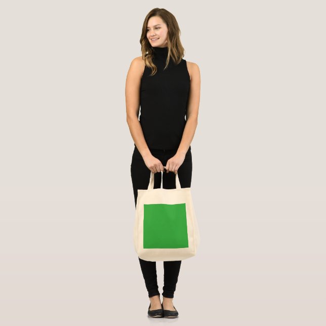 a green background with a white border tote bag (Front (Model))