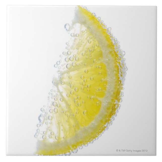 A juicy ripe organic lemon wedge fruit submerged tile (Front)