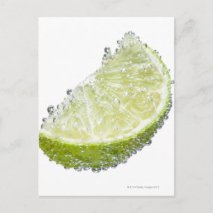 A juicy ripe organic lime wedge fruit submerged postcard