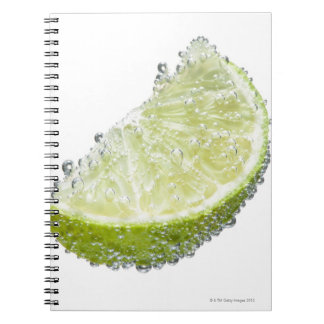 A juicy ripe organic lime wedge fruit submerged spiral notebook