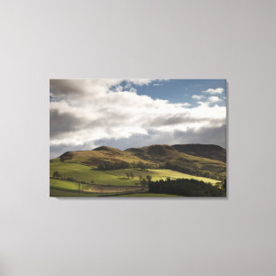 A Landscape With Rolling Hills And Clouds Overhead Canvas Print