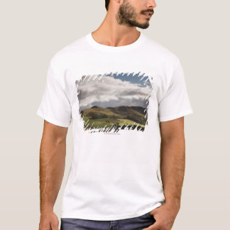 A Landscape With Rolling Hills And Clouds Overhead T-Shirt