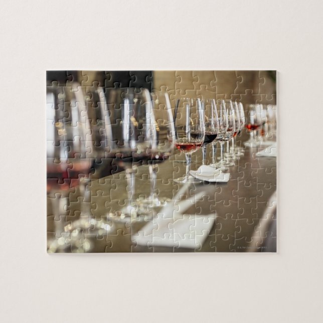 A long row of wine glasses set up so a large jigsaw puzzle (Horizontal)