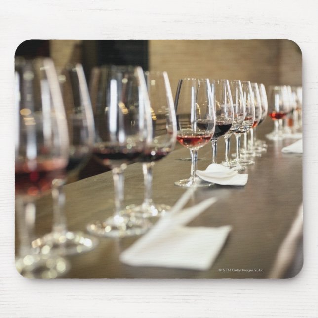 A long row of wine glasses set up so a large mouse pad (Front)