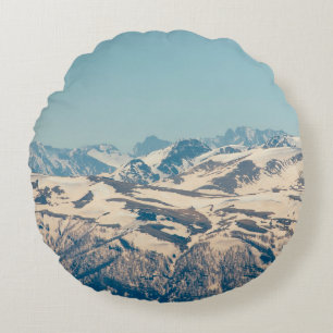 A mountain range with thawing snow and ice in the round cushion