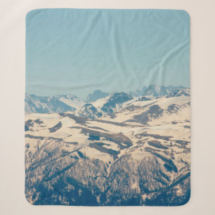 A mountain range with thawing snow and ice in the  sherpa blanket