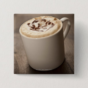 A mug of Cappuccino coffee topped with melted 15 Cm Square Badge