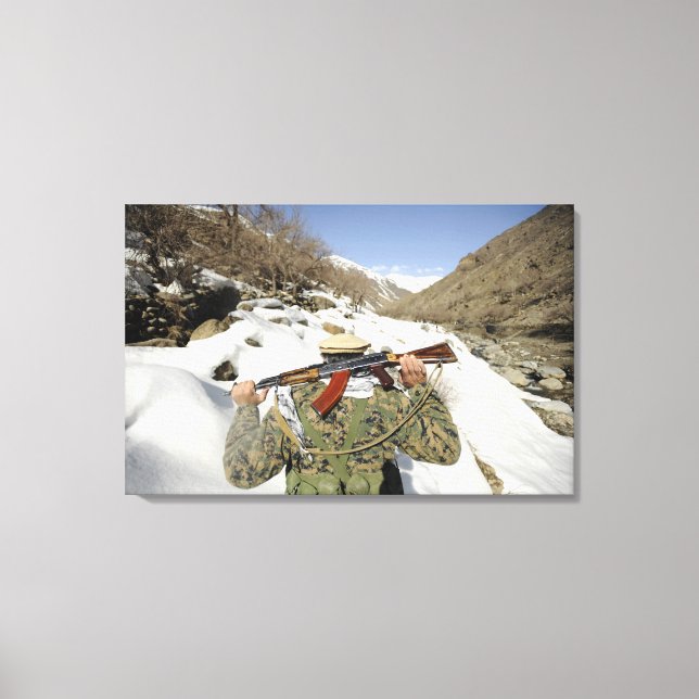 A Mujahadeen Guard walks with US Military membe Canvas Print (Front)