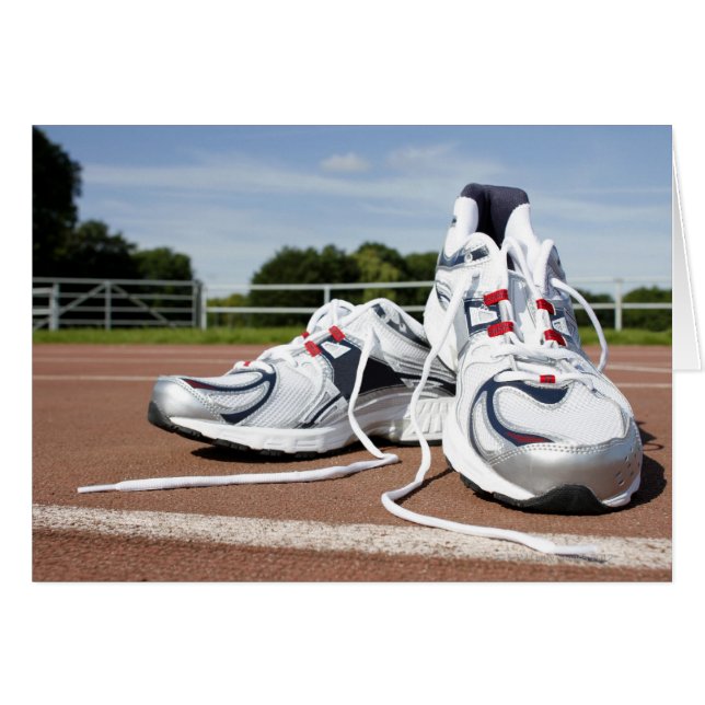 A pair of new white running trainers are placed (Front Horizontal)