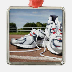A pair of new white running trainers are placed metal tree decoration