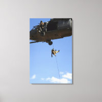 A pararescueman rappels from an HH-60