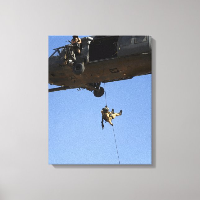A pararescueman rappels from an HH-60 Canvas Print (Front)